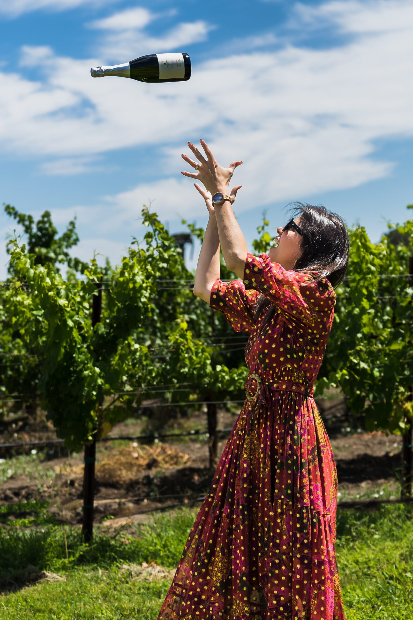 business branding photo of a tour guide in Napa Valley throwing a wine bottle into the air