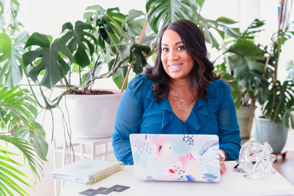 brand photo of a small business owner on her desk, among a lot of plants