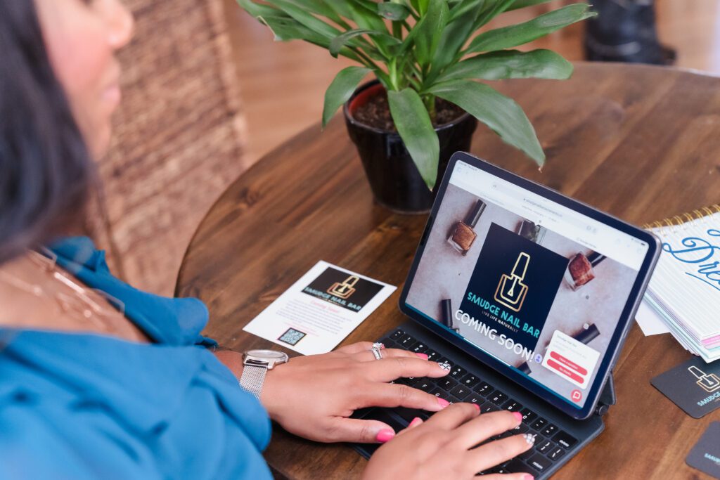 brand photo of a business owner with her hands on the computer showcasing her business's upcoming launch.