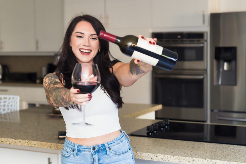 brand photo of a fitness coach celebrating with a bottle of wine


