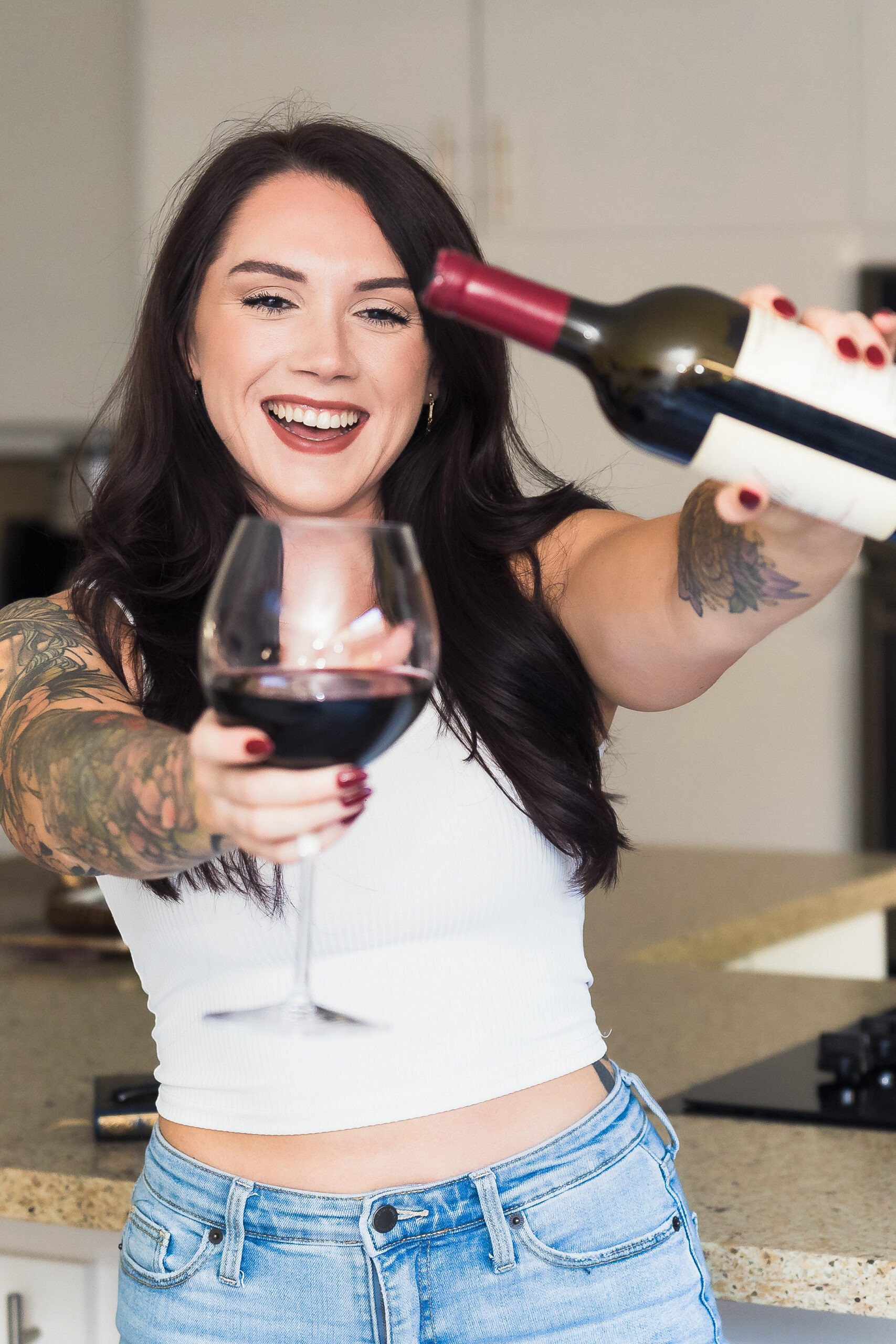 a woman holds a glass of wine and celebrates.