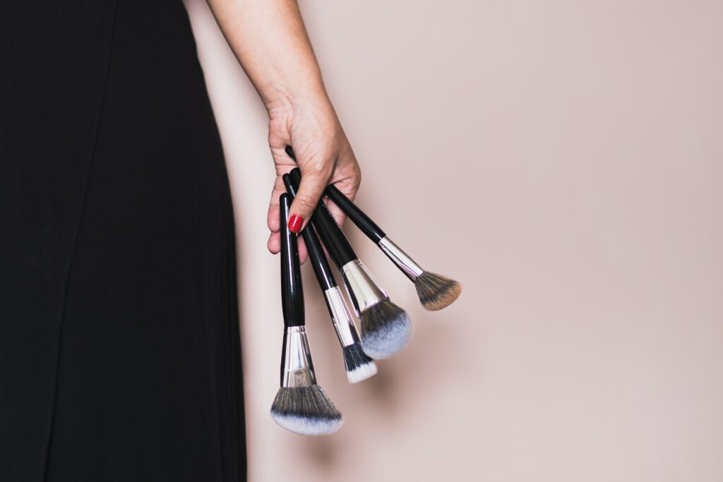 make up artist's hand holding a few brushes