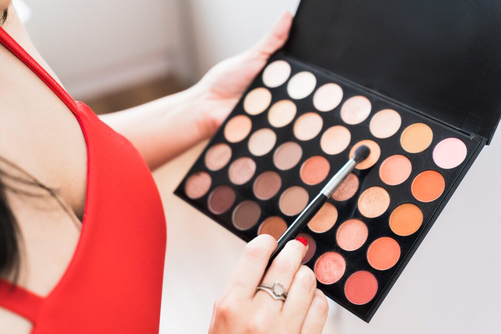 detail photo of a palette of eye shadow held by a makeup artist
