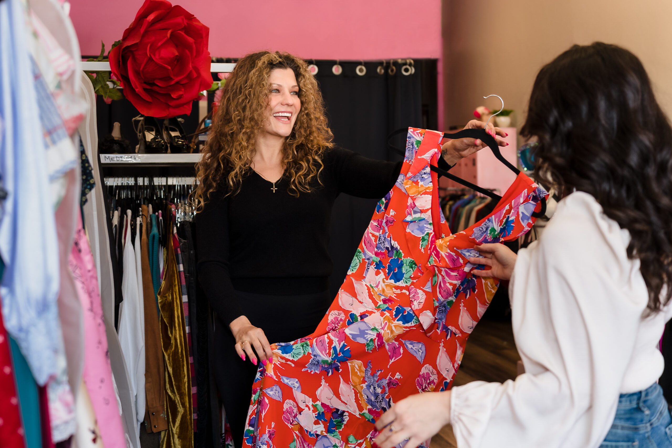 brand photo of a business owner showing a dress to a client.