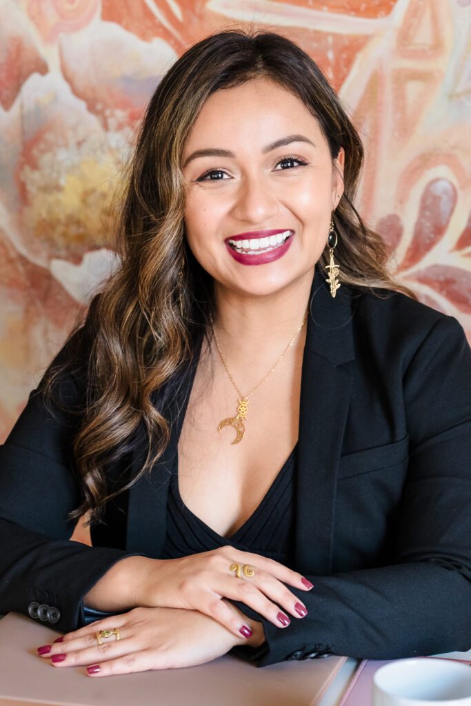 headshot of a coach, both hands posing in the notebook, smiling.