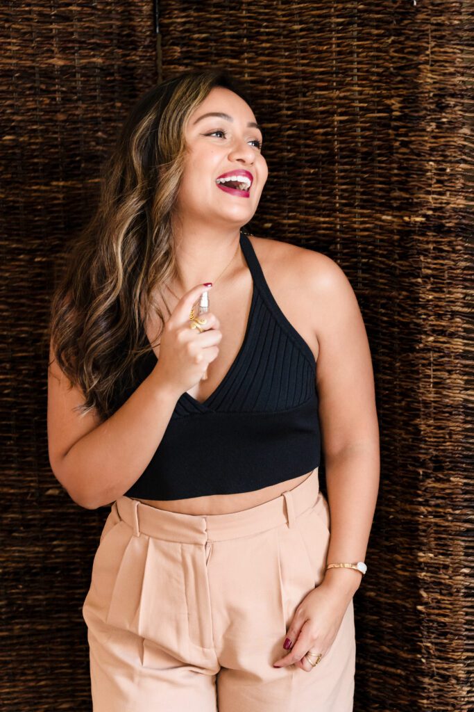 woman putting a perfume  and smiling