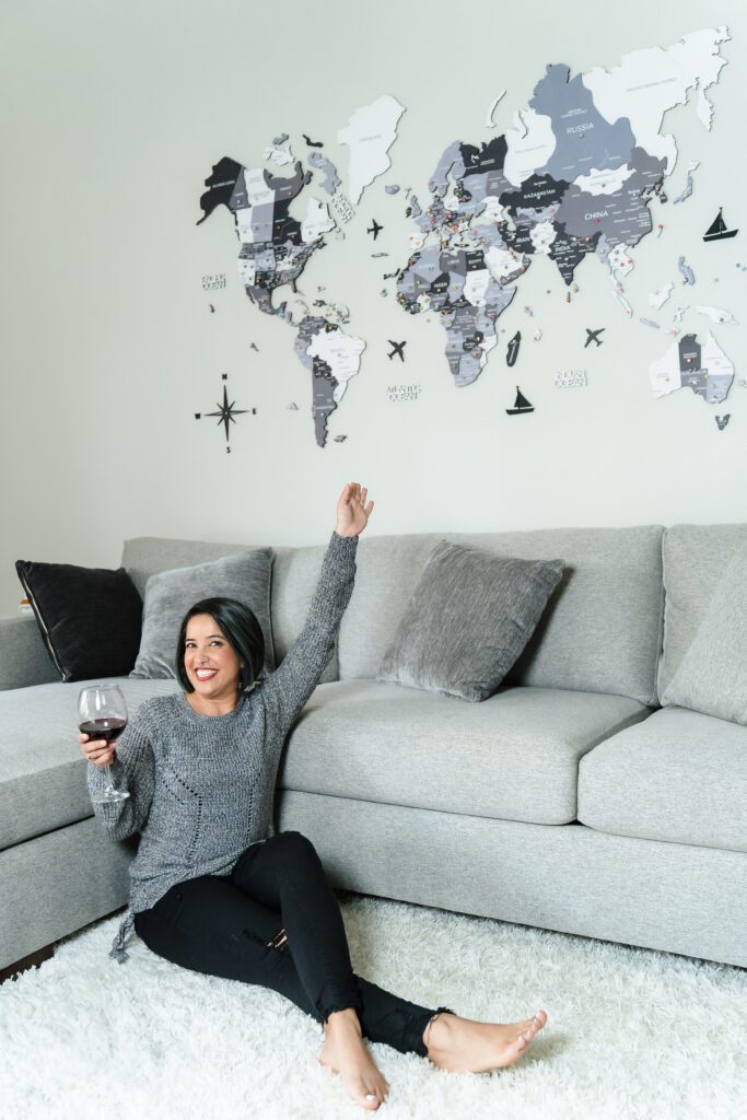 woman sit in a cozy living room rug, along with a glass of wine 