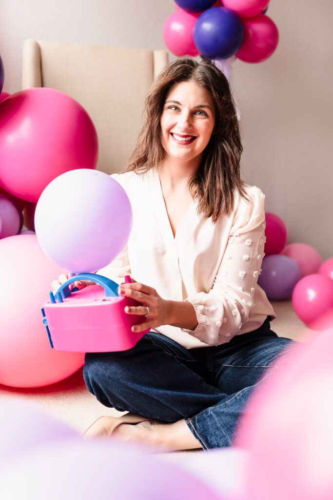 brand photo of a balloon decoration owner holding a machine-inflating balloon