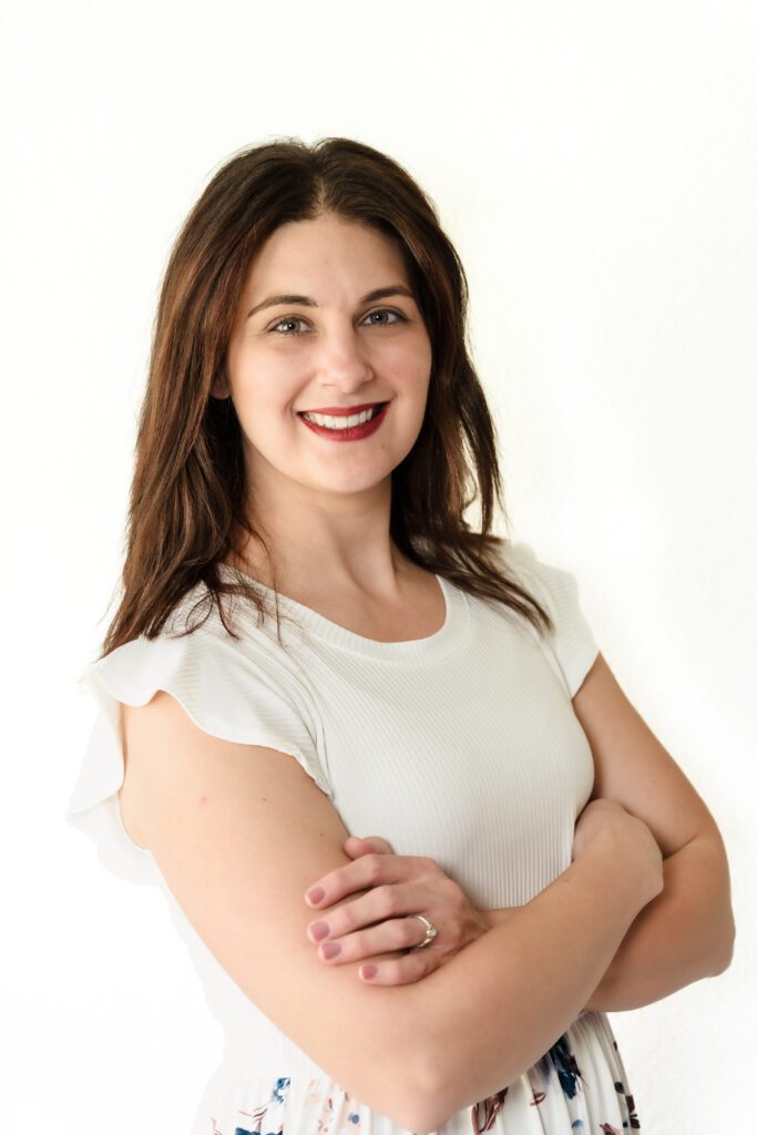 Headshot of a woman, arms crossed and smiling