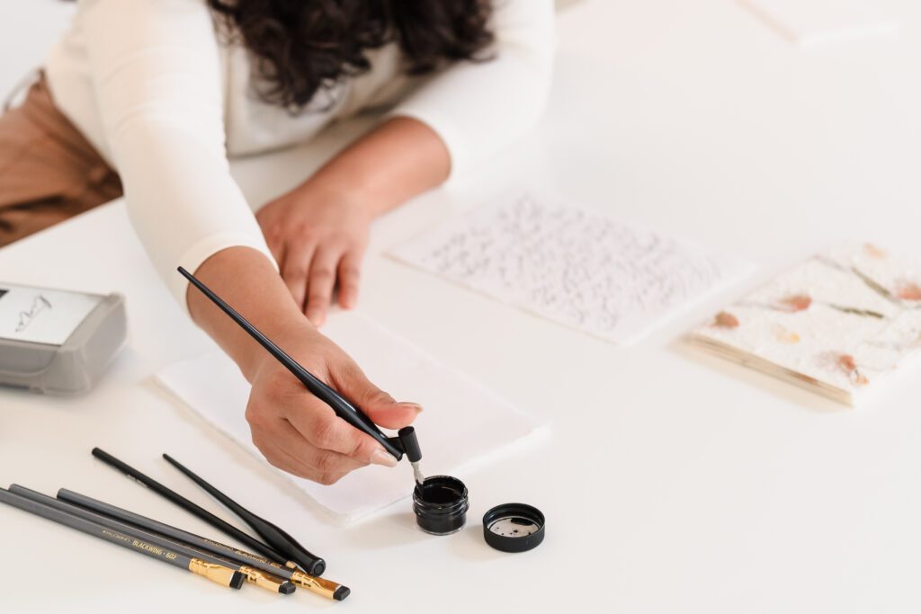 brand photo of a calligrapher's hands doing calligraphy