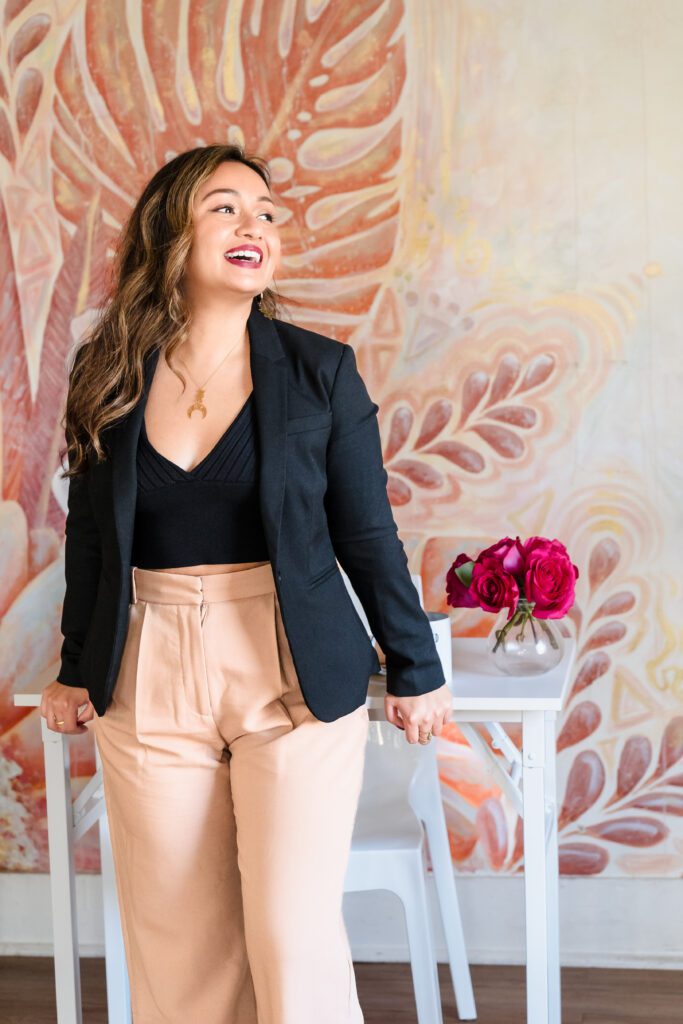 woman leaning on the desk, looking away and smiling