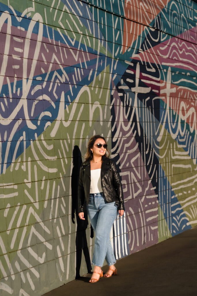 woman walking close a colorful mural