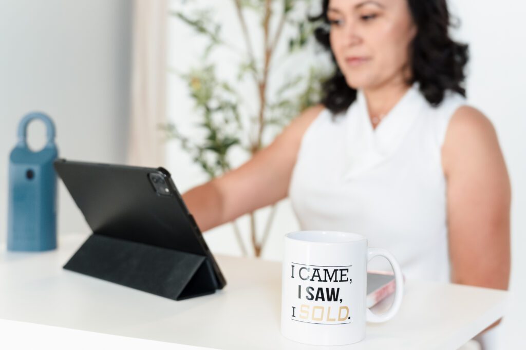 a realtor working on her desk, on-brand coffee mug on focus