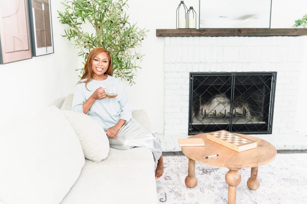 woman posing in a boho vibe living room with a cup of coffee