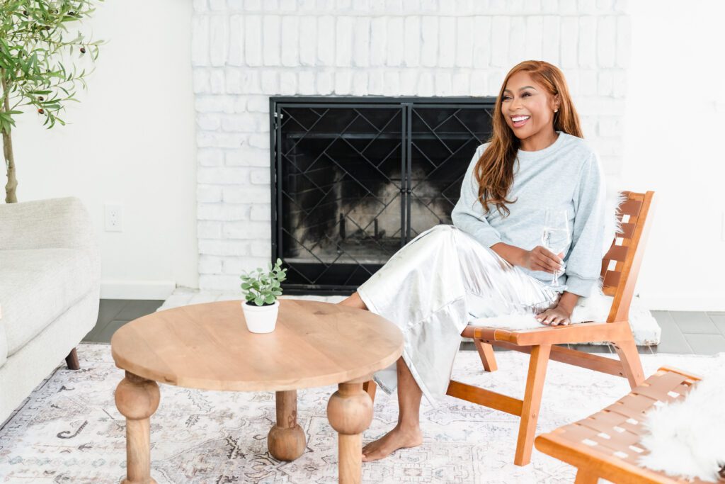 woman posing seated in a cozy living room, smiling
