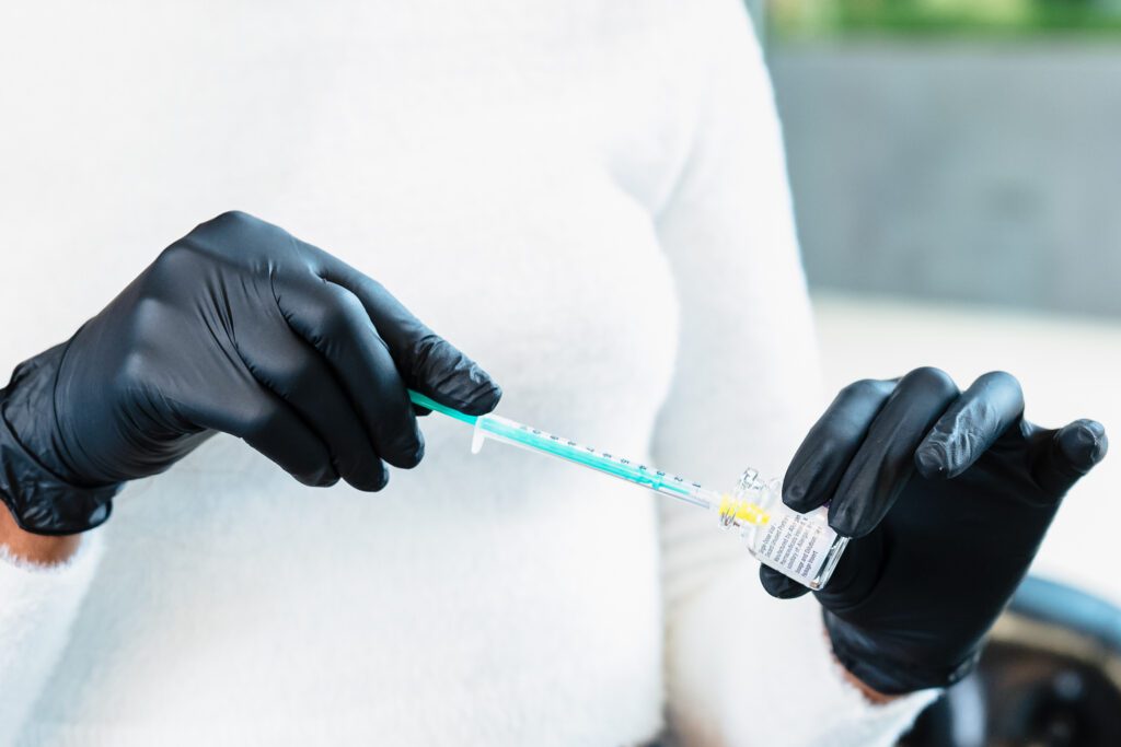 detail shot of a nurse injector's hand with a botox needle