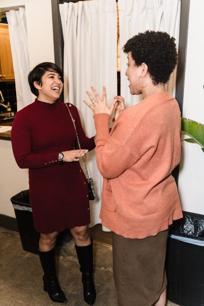 Two women engaging in lively conversation during a women-focused business networking event in Sacramento, photographed by Geise Pinto Photography.