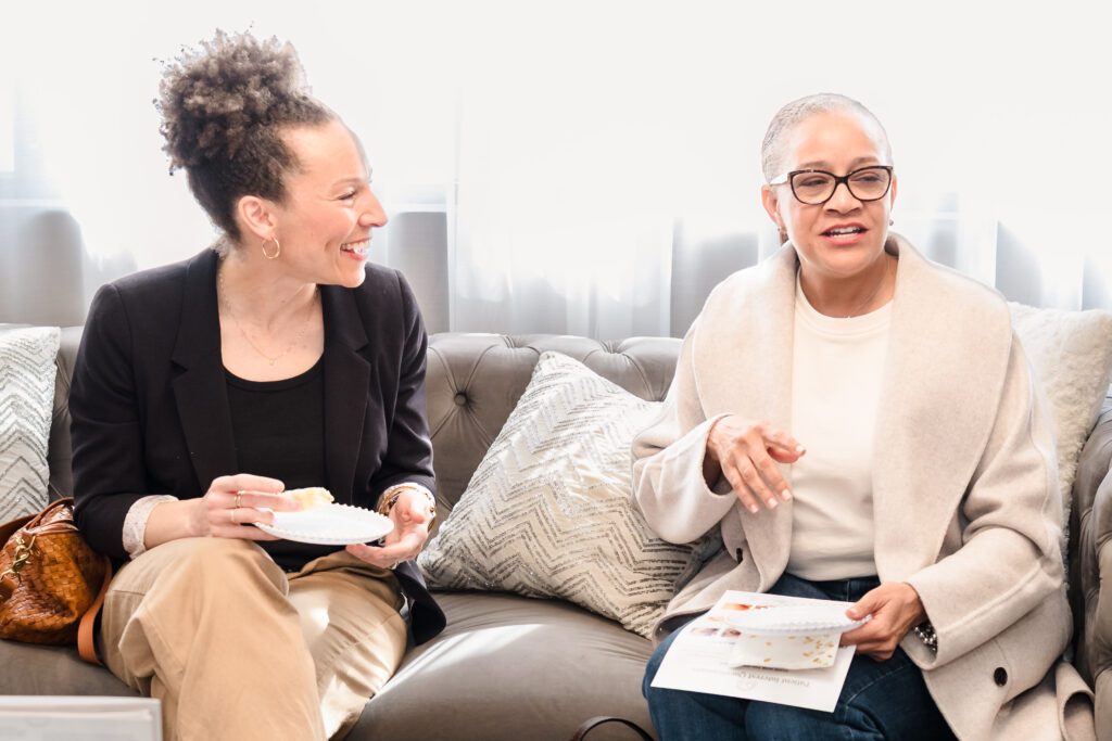 Two women connecting over conversation and light refreshments at a wellness networking event in Sacramento, hosted at Destination Aesthetic and captured by Geise Pinto Photography.