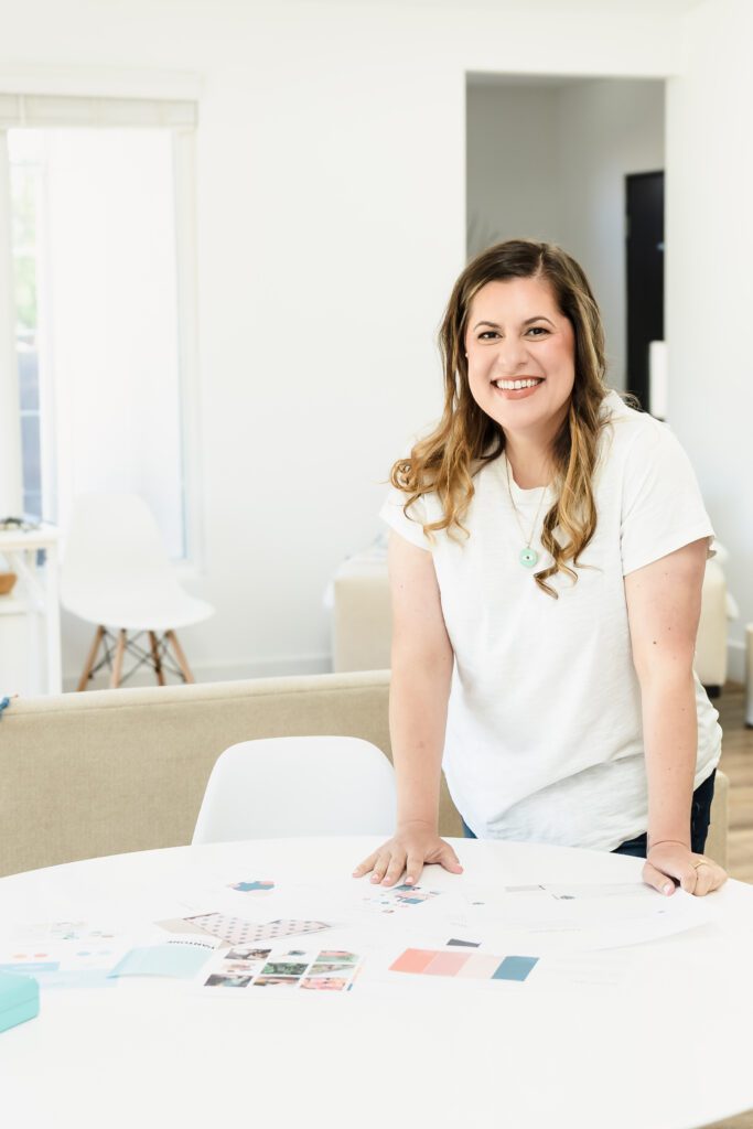 web designer posing, leaning on the desk, full of work papers